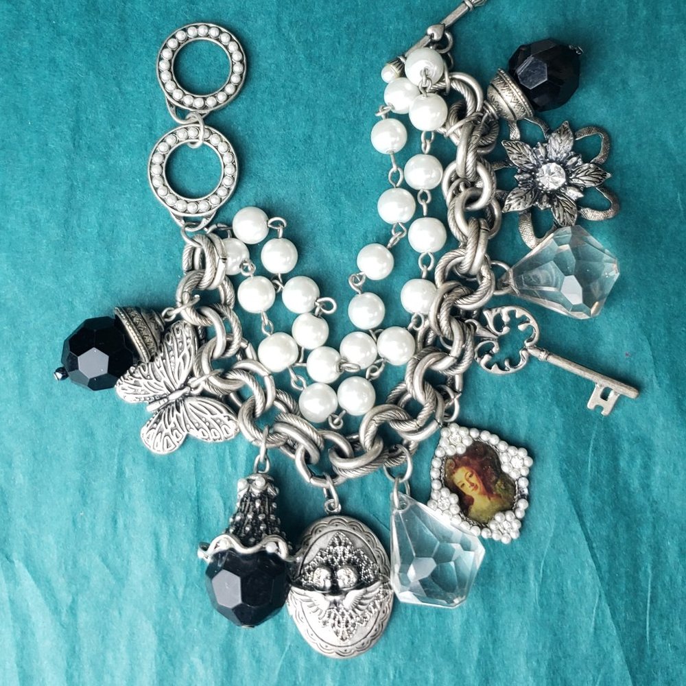 2/25$ Silver tone bracelet with charms and locket